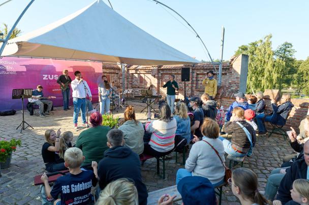 Jugendliche musizieren auf der Bühne vor Publikum